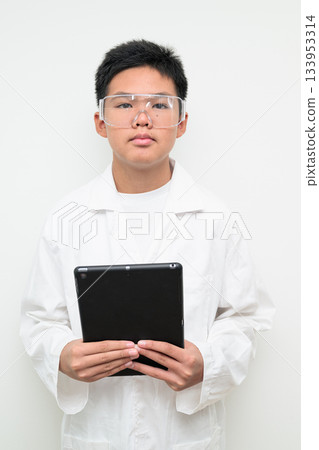 Young Asian Boy Dressed as Scientist with Lab Coat Using Digital Tablet Computer Young Asian Boy Dressed as Scientist with Lab Coat Using Digital Tablet Computer 133953314