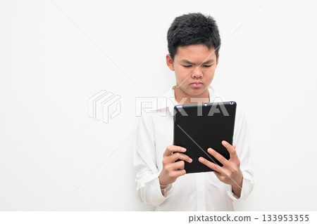 Asian Teenage Boy Student Studio Portrait on White Background Using Digital Tablet Computer Asian Teenage Boy Student Studio Portrait on White Background Using Digital Tablet Computer 133953355