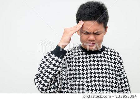 Asian Teenage Boy Studio Portrait on White Background Having Migraine Headache and Stress Asian Teenage Boy Studio Portrait on White Background Having Migraine Headache and Stress 133953384