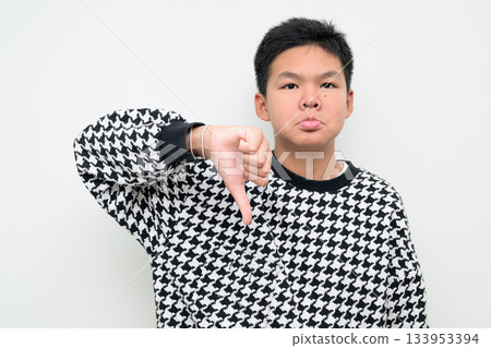 Asian Teenage Boy Studio Portrait on White Background Thumbs Down Disapproval Rejection Gesture Asian Teenage Boy Studio Portrait on White Background Thumbs Down Disapproval Rejection Gesture 133953394