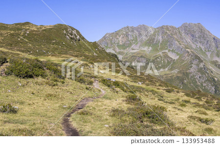 Hiking trail at Europaschutzgebiet Verwall near Grasjoch in Sankt Gallenkirch, with mountains Hochjoch and Mittagsjoch ahead Hiking trail at Europaschutzgebiet Verwall near Grasjoch in Sankt Gallenkirch, with mountains Hochjoch and Mittagsjoch ahead 133953488