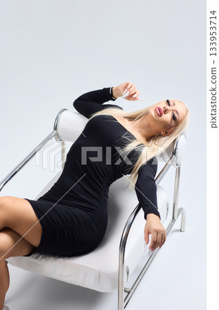 Sophisticated portrait of poised woman in professional studio environment, Refined image showcasing confident lady with braided hairstyle dressed elegantly against studio backdrop 133953714