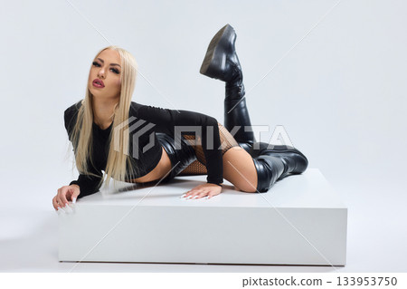 Vivid fashion scene, Dynamic photograph capturing bold fashion and fierce attitude, Fashion model leans against white cube showcasing daring attire and intense expression Vivid fashion scene, Dynamic photograph capturing bold fashion and fierce attitude, Fashion model leans against white cube showcasing daring attire and intense expression 133953750
