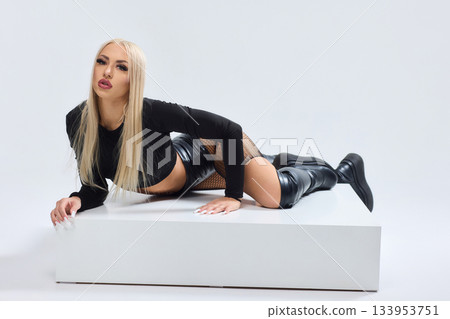 Vivid fashion scene, Dynamic photograph capturing bold fashion and fierce attitude, Fashion model leans against white cube showcasing daring attire and intense expression Vivid fashion scene, Dynamic photograph capturing bold fashion and fierce attitude, Fashion model leans against white cube showcasing daring attire and intense expression 133953751