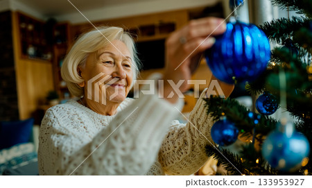 A woman decorating a Christmas tree with blue ornaments A woman decorating a Christmas tree with blue ornaments 133953927
