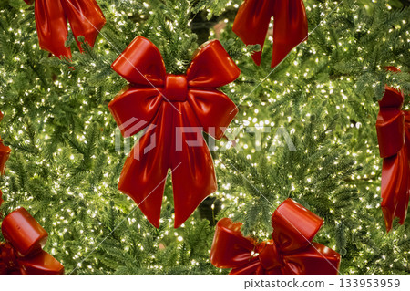 Shiny red bows decorating a Christmas tree full of sparkling warm lights. Festive and joyful holiday atmosphere. Shiny red bows decorating a Christmas tree full of sparkling warm lights. Festive and joyful holiday atmosphere. 133953959