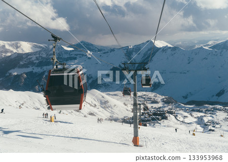 Ski lift in Gudauri, Georgia, transporting skiers through snowy mountains 133953968