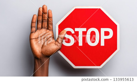 Hand Gesture Signaling Stop Beside Red Octagon Traffic Sign Hand Gesture Signaling Stop Beside Red Octagon Traffic Sign 133955613