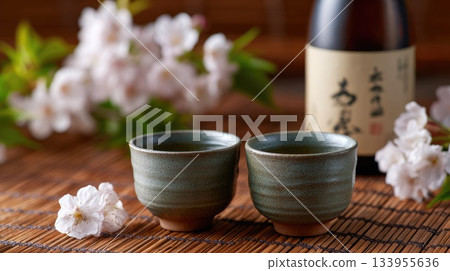 Traditional Sake Cups with Blossoms on Wooden Mat Traditional Sake Cups with Blossoms on Wooden Mat 133955636