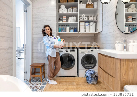 Woman housewife posing at modern white wooden bathroom laundry storage minimalism organizing 133955731