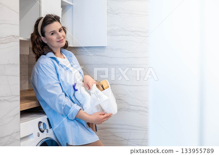 Smiling housewife female white bathroom laundry general cleaning detergent storage organizing Smiling housewife female white bathroom laundry general cleaning detergent storage organizing 133955789