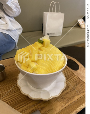Refreshing mango bingsu with fluffy shaved ice, sweet mango chunks, and creamy condensed milk. A perfect Korean dessert for hot days, offering a delightful balance of fruity and creamy flavors! 133956506