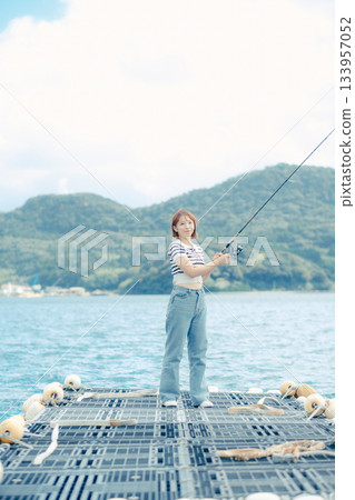 一位女士在海灘享受釣魚的樂趣 133957052