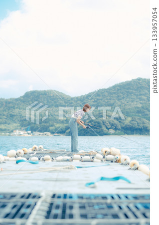 Woman enjoying fishing at the beach 133957054
