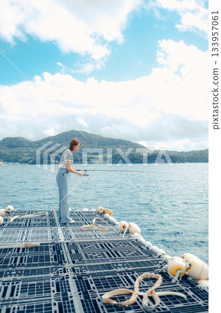 一位女士在海灘享受釣魚的樂趣 一位女士在海灘享受釣魚的樂趣 133957061