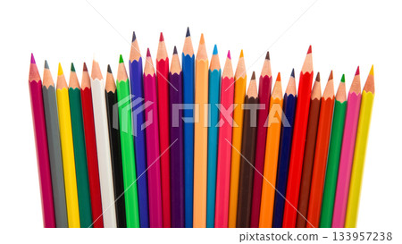 Multicolored pencils lined up in a dynamic wave formation on a white backdrop 133957238