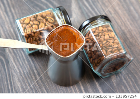 Close-up of a silver cezve with frothy Turkish coffee on a wooden table Close-up of a silver cezve with frothy Turkish coffee on a wooden table 133957254