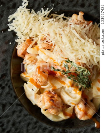 Rich seafood spaghetti with herbs, Closeup of crustaceans and noodles coated in cheesy sauce and herbs 133957422