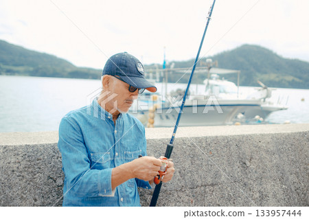 Senior man looking at fishing rod 133957444