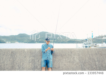 一位老人正在看釣竿 133957448