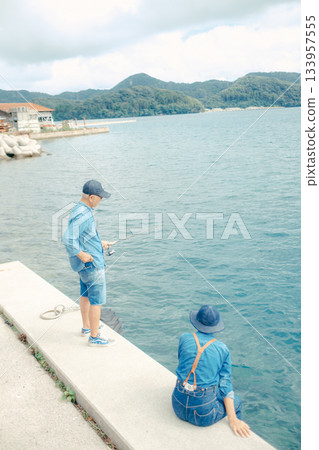 一對老年夫婦在海灘上享受釣魚的背影 133957555