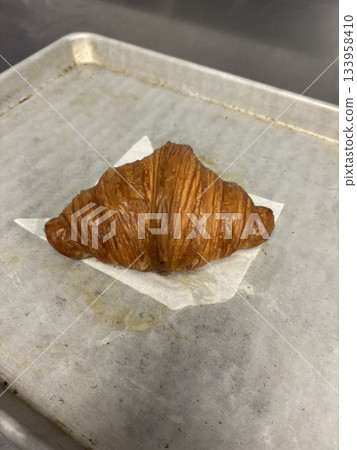 A croissant is a classic French pastry known for its buttery, flaky layers and golden crust. Often enjoyed plain or filled with chocolate, almond, or ham and cheese, it’s a perfect for breakfast A croissant is a classic French pastry known for its buttery, flaky layers and golden crust. Often enjoyed plain or filled with chocolate, almond, or ham and cheese, it’s a perfect for breakfast 133958410