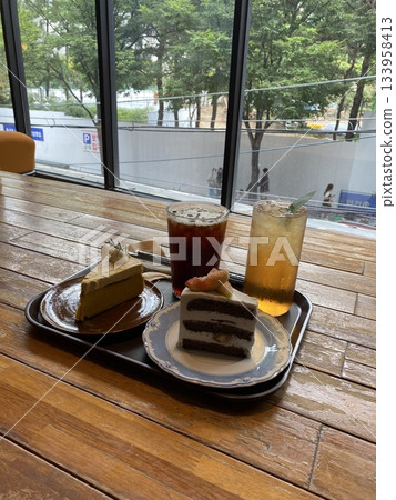 Refreshing ice americano and soft strawberry roll cake with creamy filling served on a cozy café table, offering a perfect mix of bold coffee and sweet indulgence in every peaceful bite and sip. 133958413
