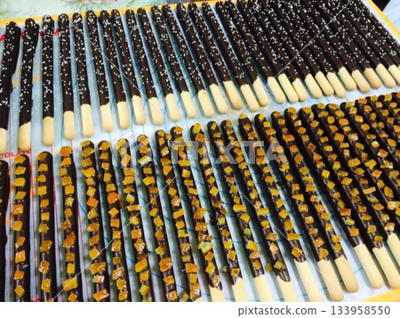 Pepero sticks coated with chocolate and sometimes topped with nuts or sprinkles. A sweet and crunchy treat, perfect for sharing or gifting on special occasions. Pepero sticks coated with chocolate and sometimes topped with nuts or sprinkles. A sweet and crunchy treat, perfect for sharing or gifting on special occasions. 133958550