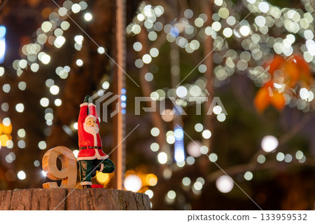 聖誕場景,聖誕老公公玩偶擺出瑜珈姿勢,燈光模糊不清。 聖誕場景,聖誕老公公玩偶擺出瑜珈姿勢,燈光模糊不清。 133959532