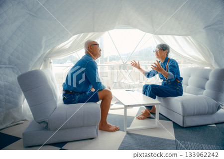 Conversation scene of a senior couple relaxing at a glamping facility 133962242