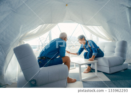 Senior couple enjoying taking photos with their smartphone at a glamping facility Senior couple enjoying taking photos with their smartphone at a glamping facility 133962293
