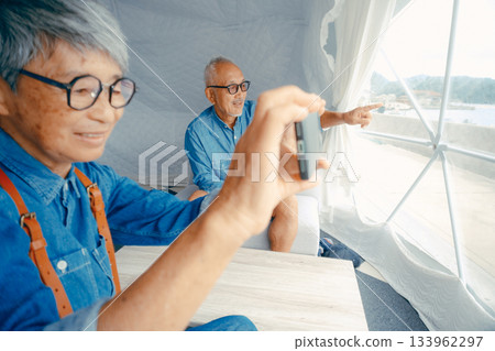 一對老年夫婦在豪華露營地用智慧型手機拍照玩得很開心 一對老年夫婦在豪華露營地用智慧型手機拍照玩得很開心 133962297