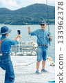 一對老年夫婦正在為他們釣到的魚拍紀念照。 133962378
