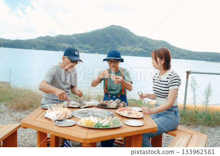 三個家長帶著孩子在湖邊享受燒烤的場景 三個家長帶著孩子在湖邊享受燒烤的場景 133962581