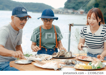 三個家長帶著孩子在湖邊享受燒烤的場景 133962584