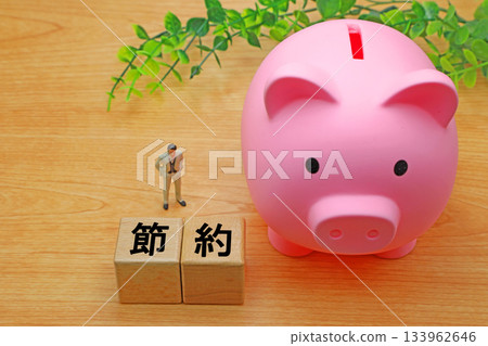 A block with the word "saving" written on it and a piggy bank 133962646