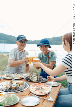 海灘上,三位家長和孩子們舉杯慶祝的場景 海灘上,三位家長和孩子們舉杯慶祝的場景 133962731