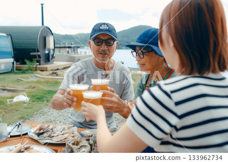 A scene of three parents and children toasting at the beach A scene of three parents and children toasting at the beach 133962734