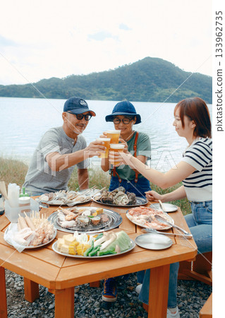 海灘上,三位家長和孩子們舉杯慶祝的場景 海灘上,三位家長和孩子們舉杯慶祝的場景 133962735