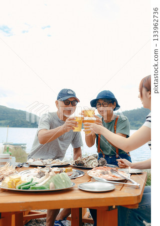 海灘上,三位家長和孩子們舉杯慶祝的場景 海灘上,三位家長和孩子們舉杯慶祝的場景 133962736