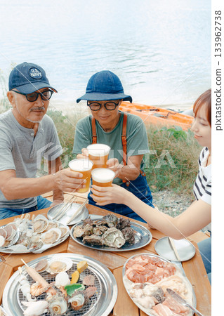 海灘上，三位家長和孩子們舉杯慶祝的場景 133962738