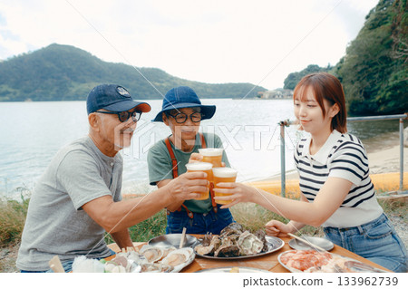 A scene of three parents and children toasting at the beach 133962739