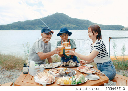 海灘上，三位家長和孩子們舉杯慶祝的場景 133962740