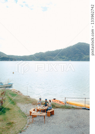 海灘上,三位家長和孩子們舉杯慶祝的場景 海灘上,三位家長和孩子們舉杯慶祝的場景 133962742