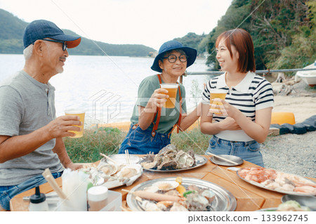 海灘上，三位家長和孩子們舉杯慶祝的場景 133962745