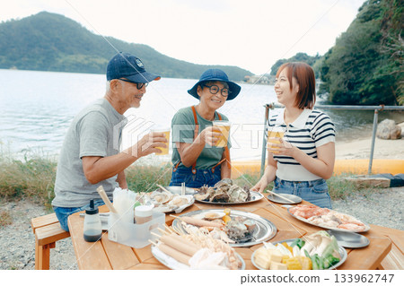 海灘上,三位家長和孩子們舉杯慶祝的場景 海灘上,三位家長和孩子們舉杯慶祝的場景 133962747