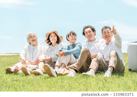 一個可以看到藍天的公園,一個坐在山上的家庭,父母和孩子,一個三代家庭(父親,母親,女兒,祖母,祖父) 一個可以看到藍天的公園,一個坐在山上的家庭,父母和孩子,一個三代家庭(父親,母親,女兒,祖母,祖父) 133963371