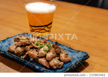 傍晚時分，人們一邊享用烤雞串和啤酒，一邊看著木桌上擺放著各種日式小吃。 133963462