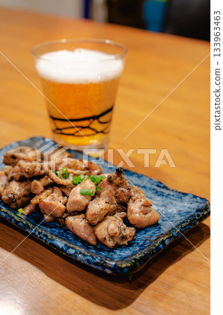 傍晚時分，人們一邊享用烤雞串和啤酒，一邊看著木桌上擺放著各種日式小吃。 133963463