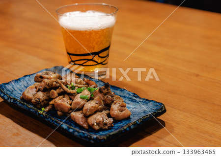 傍晚時分，人們一邊享用烤雞串和啤酒，一邊看著木桌上擺放著各種日式小吃。 133963465